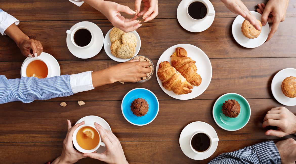 les gens les mains sur la table en bois avec des croissants et du cafe 1 - ABPE
